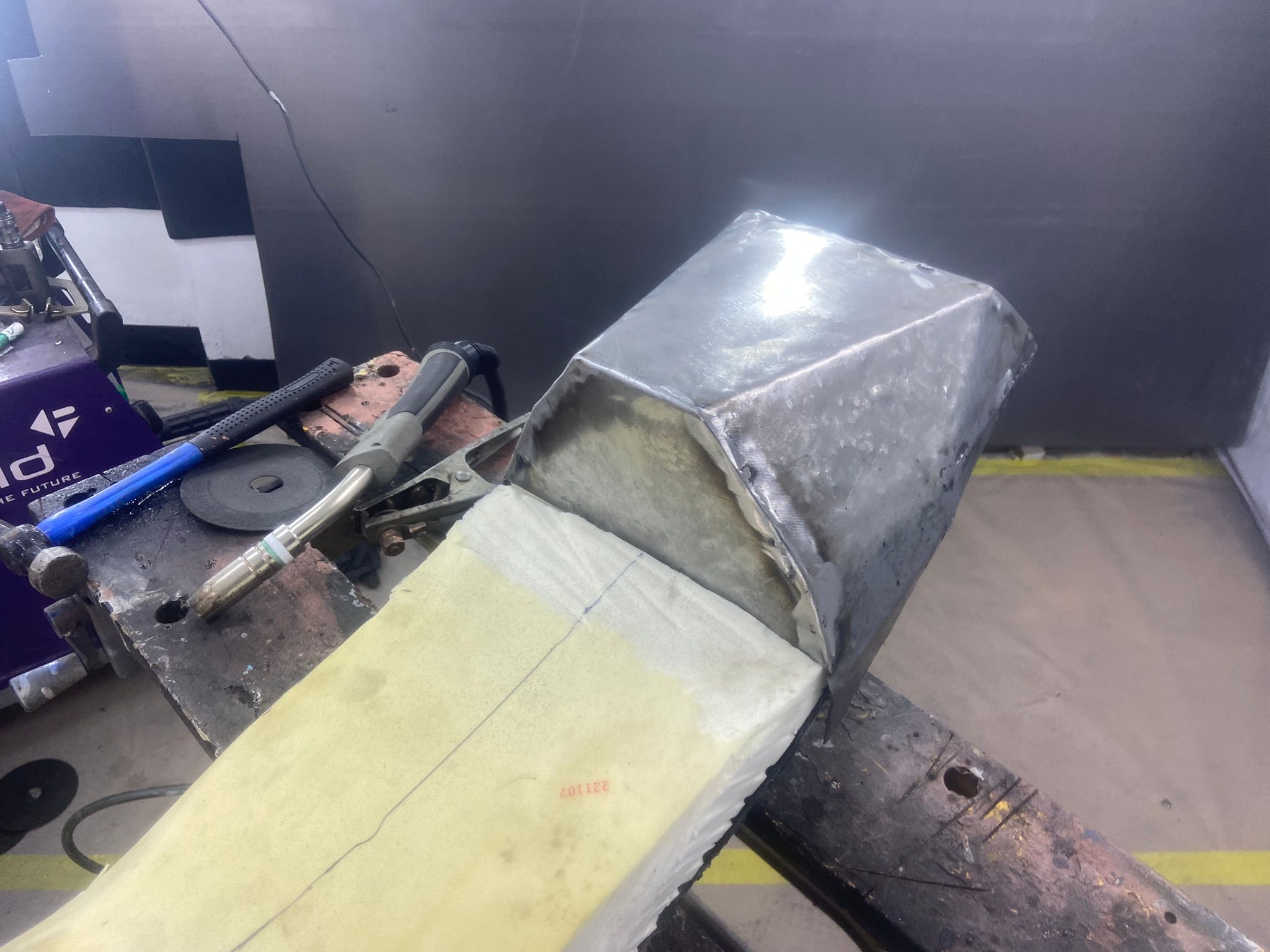 Custom rear seat hump being fabricated from sheet metal at Top Touch Coachworks – cardboard aided design prototype