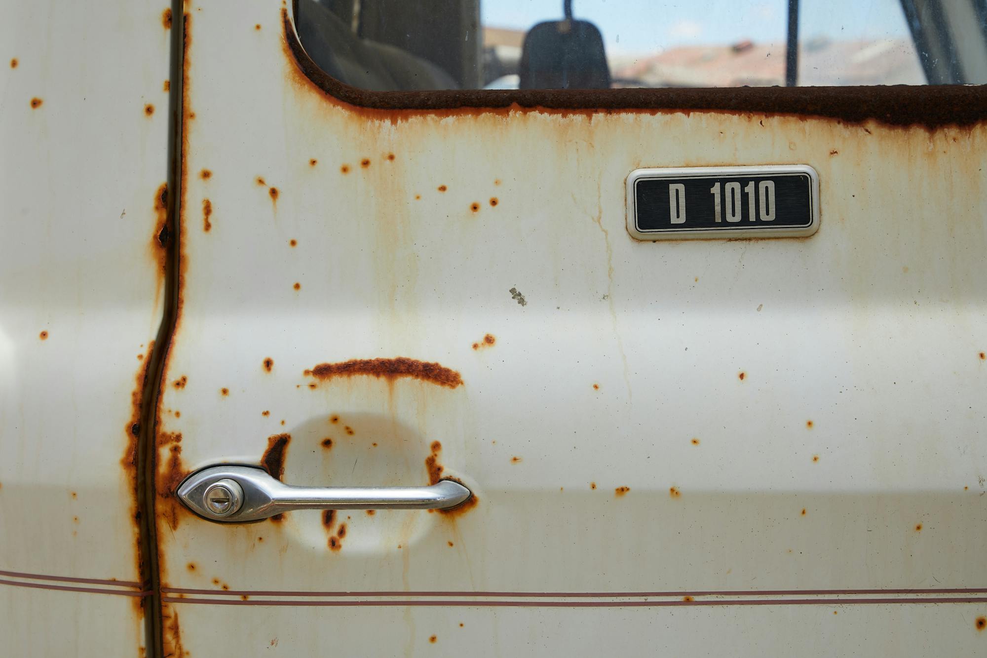 Severe hidden rust corrosion on a classic Ford Escort door panel — the kind that lurks under fresh paint