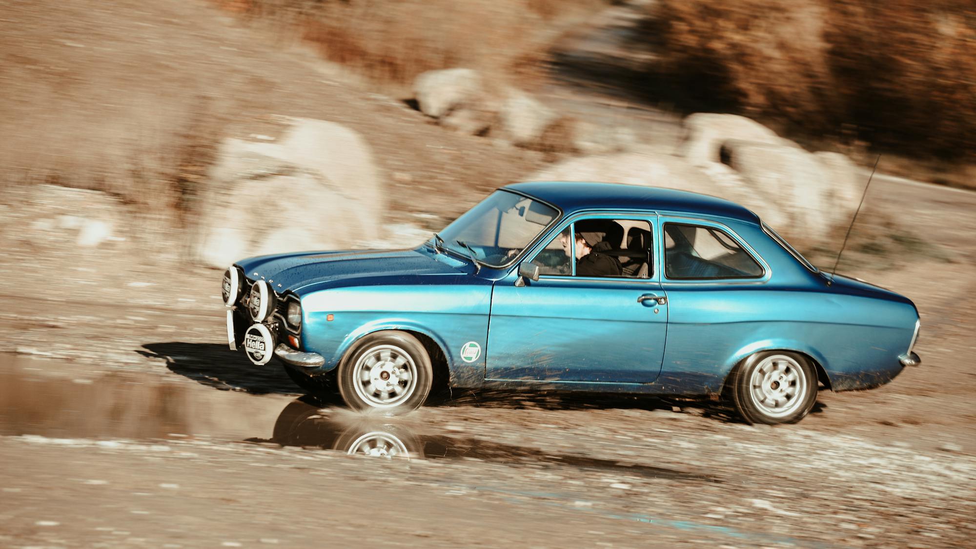 Classic blue Ford Escort Mk6 driving along a dirt road — Cosworth-era looks at GTI money