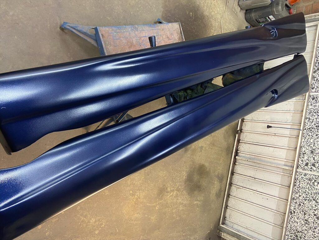 Freshly sprayed dark blue side skirts drying in workshop, panel respray by Top Touch Coachworks