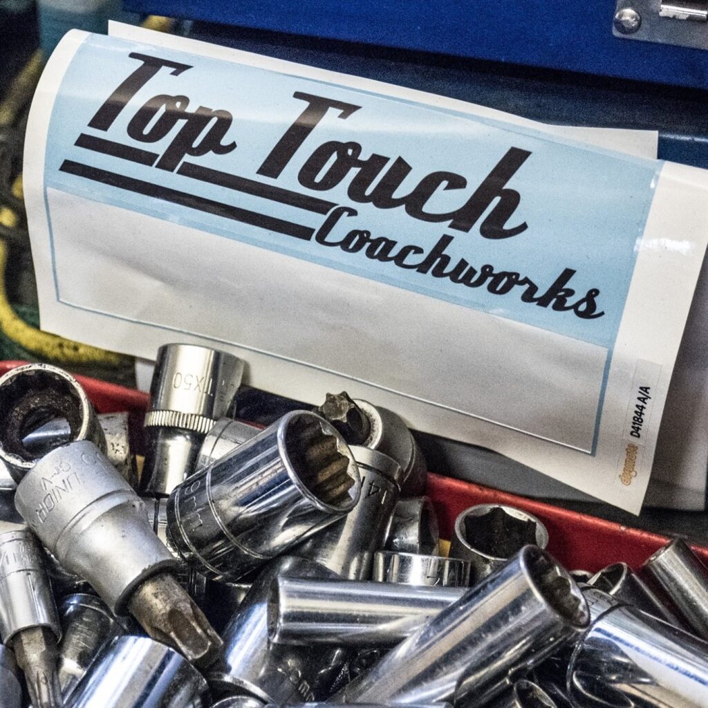 Top Touch Coachworks sticker on toolbox with sockets, workshop near Wicken