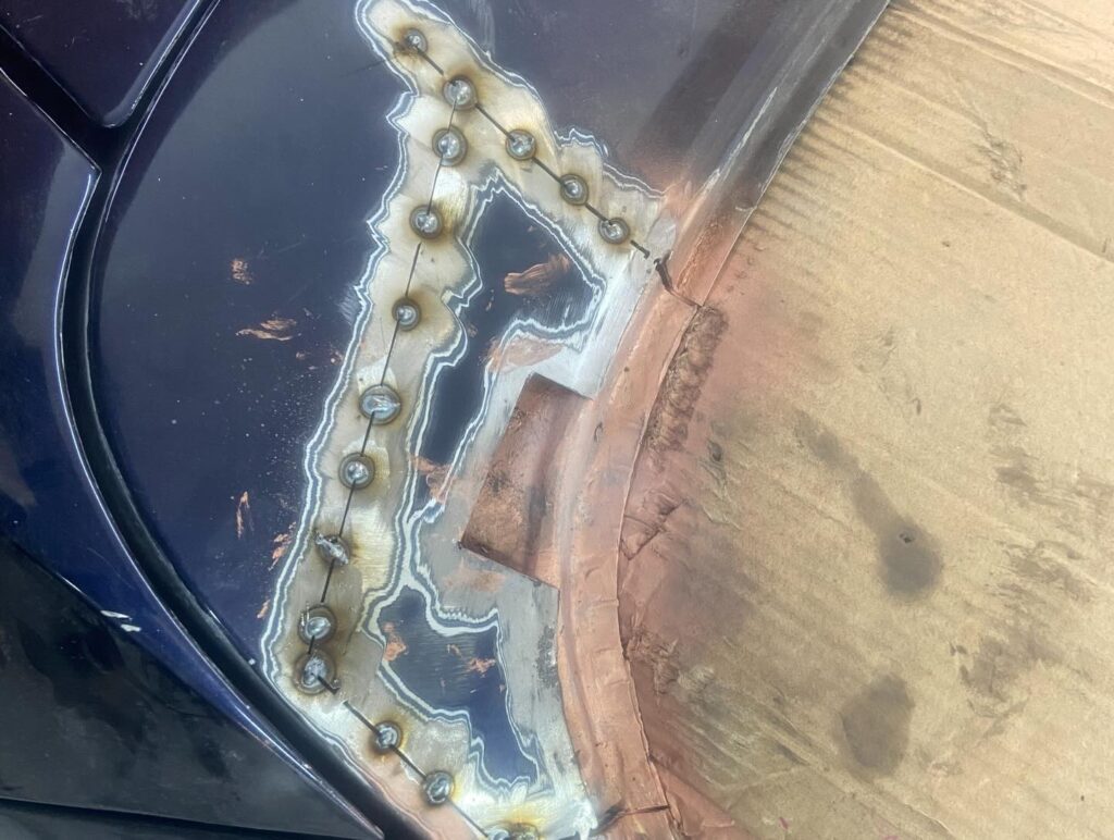 Plug welds on wheel arch repair with corrosion cut out, welding near Milton Keynes