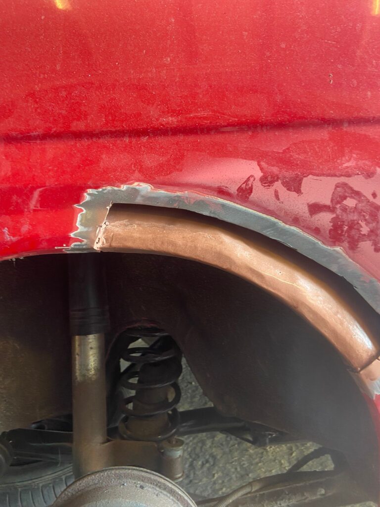 Ford Fiesta Mk2 rear wheel arch corrosion repair with new fabricated metal welded in and primer applied
