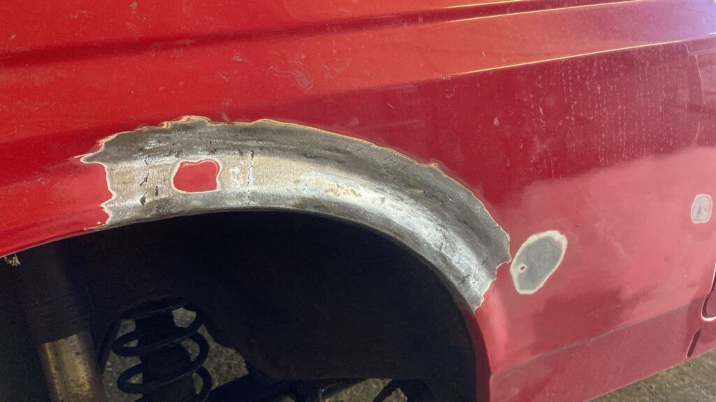 Ford Fiesta Mk2 rear wheel arch ground back to bare metal exposing corrosion before fabrication and welding