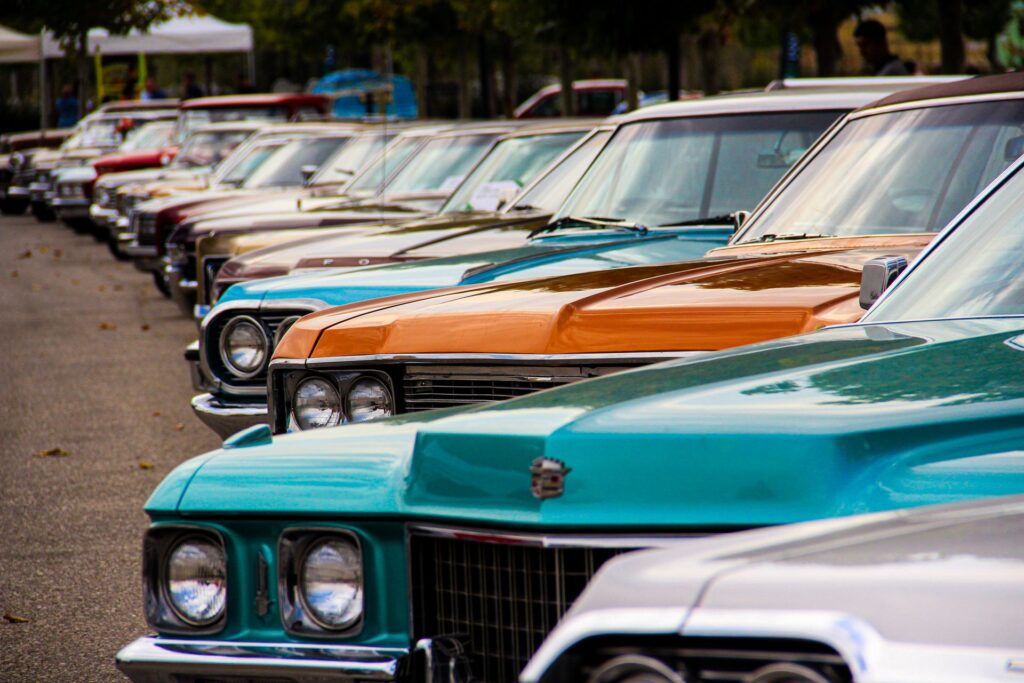A row of classic vintage cars displayed outdoors at a show