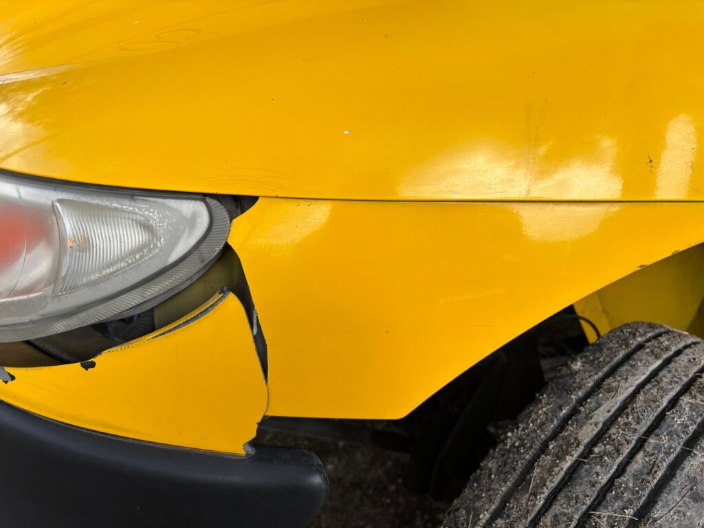 Close-up of damage to a car's painted front bodywork